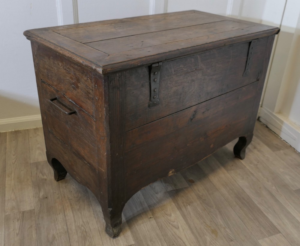 An 18th-century small dark oak French coffer featuring a flat top, central wrought iron escutcheon, and subtle cabriole legs. View VII