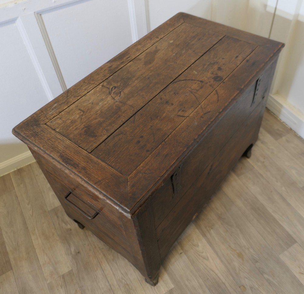 An 18th-century small dark oak French coffer featuring a flat top, central wrought iron escutcheon, and subtle cabriole legs. View VIII