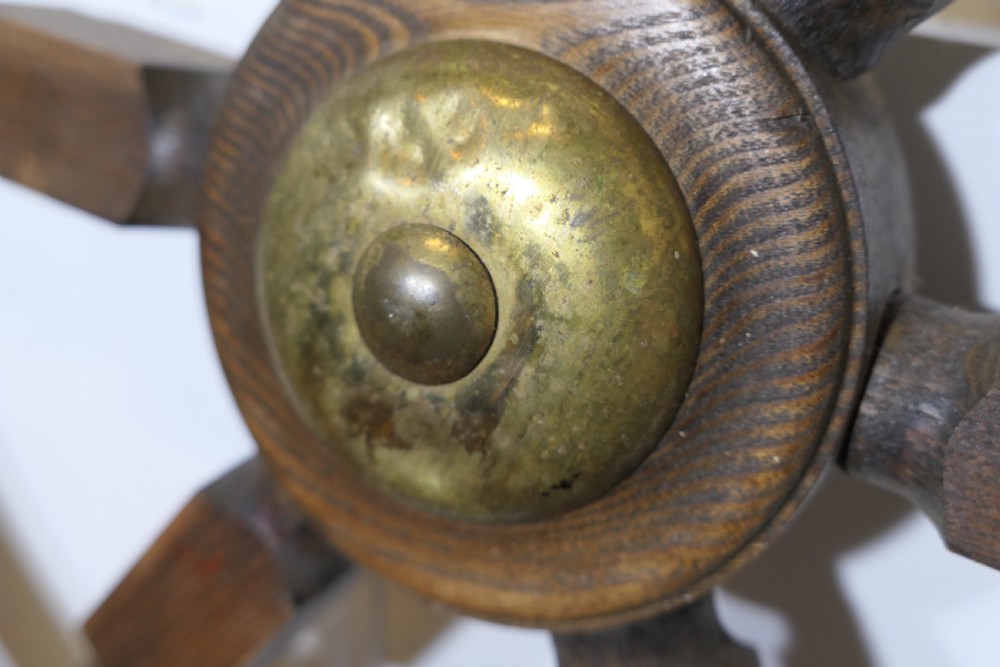 An early twentieth-century oak ship wheel featuring eight turned spokes and a central brass hub. View VII