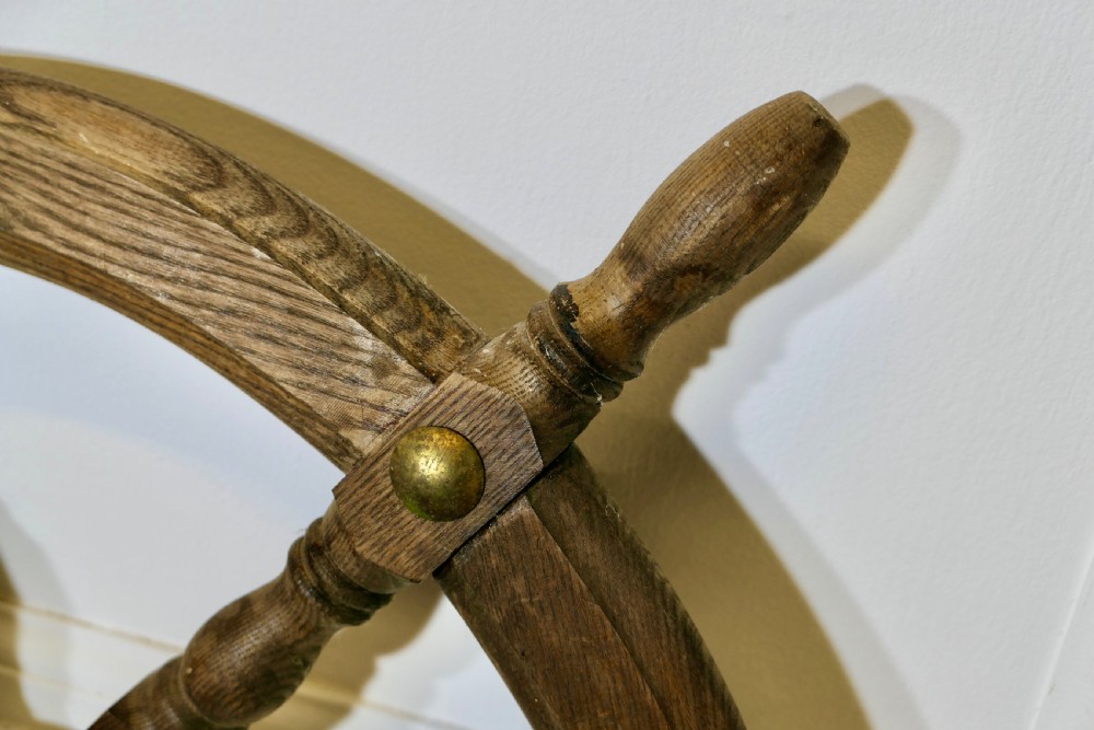 An early twentieth-century oak ship wheel featuring eight turned spokes and a central brass hub. View VIII