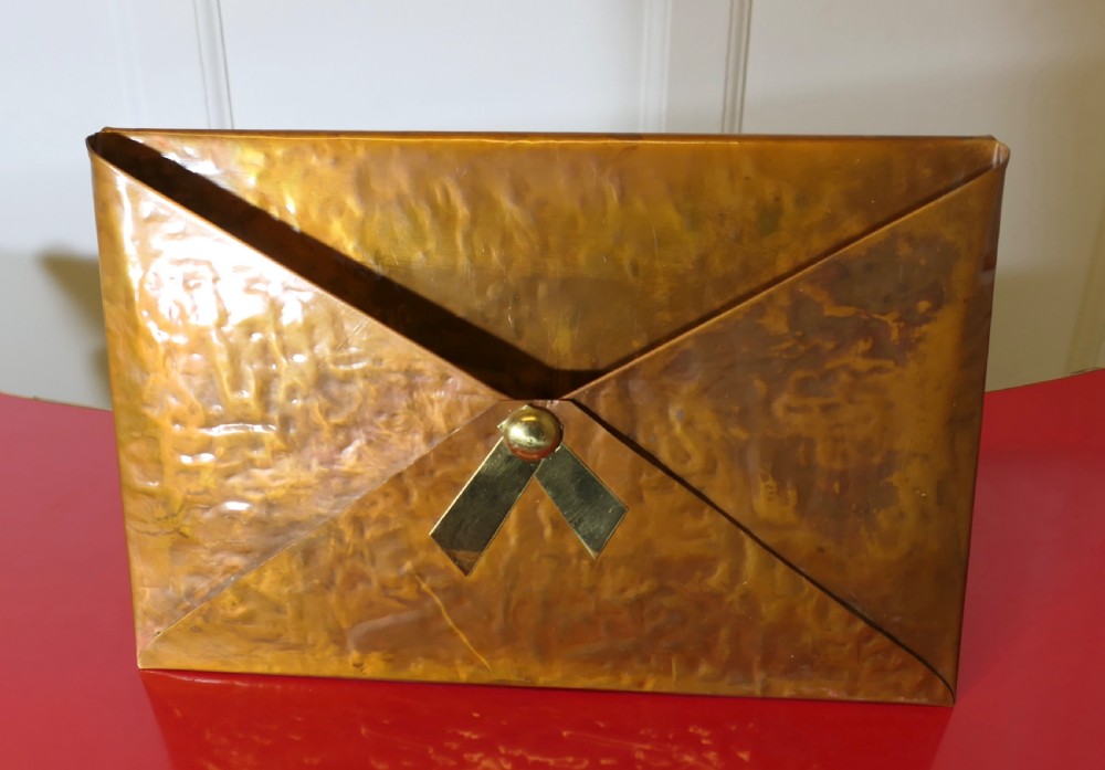 A hammered copper letter rack fashioned in the shape of an envelope, featuring a brass rivet and clasp detail. View II