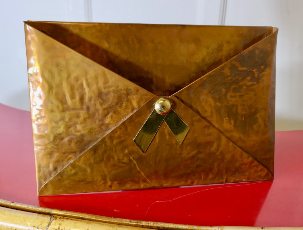 A hammered copper letter rack fashioned in the shape of an envelope, featuring a brass rivet and clasp detail. View V