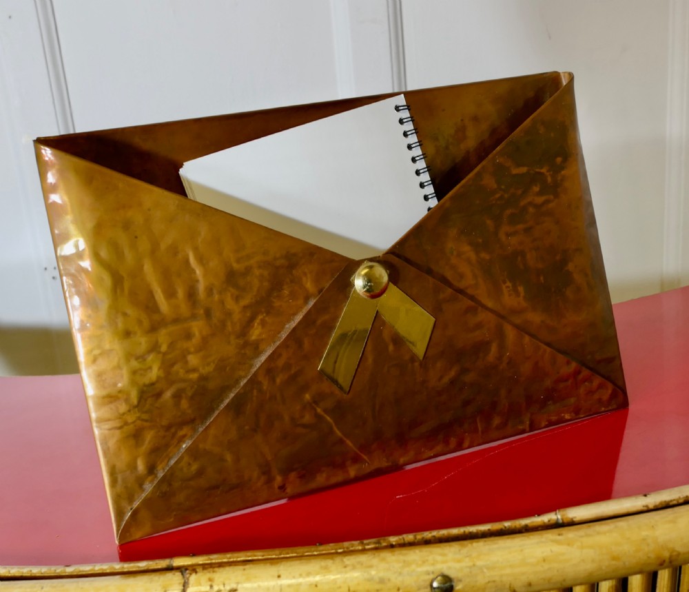 A hammered copper letter rack fashioned in the shape of an envelope, featuring a brass rivet and clasp detail. View VI