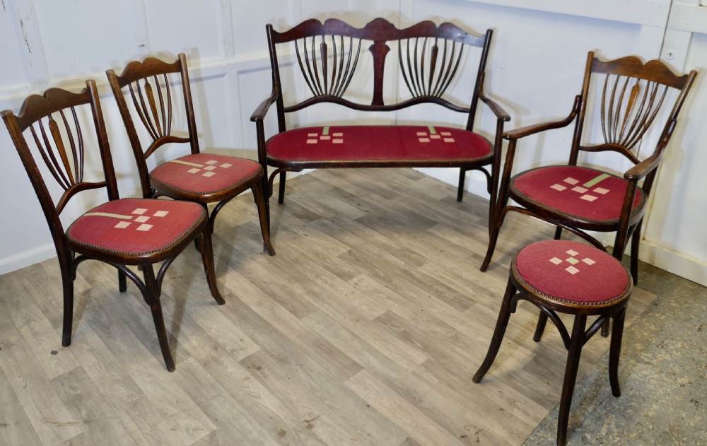 A five-piece dark bentwood salon suite comprising a two-seater settee, two side chairs, an armchair, and a circular stool with red upholstered seats. View II