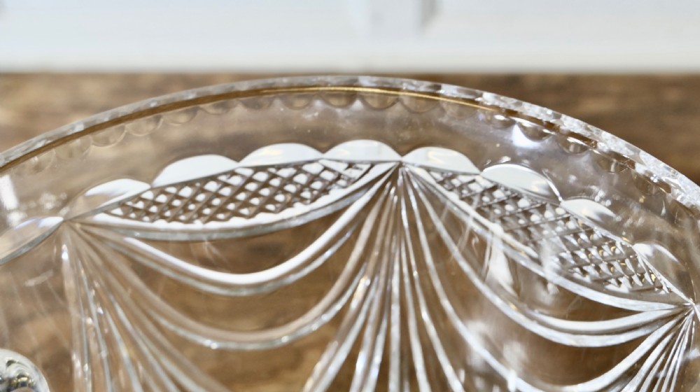 A heavy clear cut crystal champagne ice bucket featuring geometric drapery cuts, two applied scroll handles, and a stepped circular base. View IV