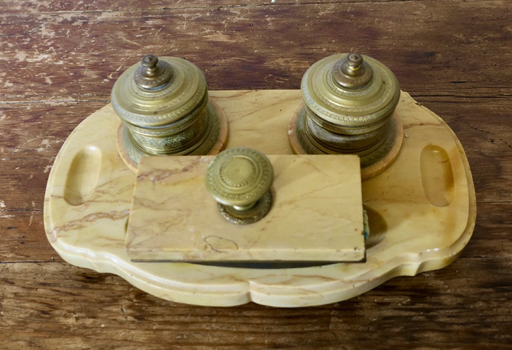 A French veined marble inkstand featuring two turned brass inkpots and a matching rectangular marble rocker blotter set on a shaped base.