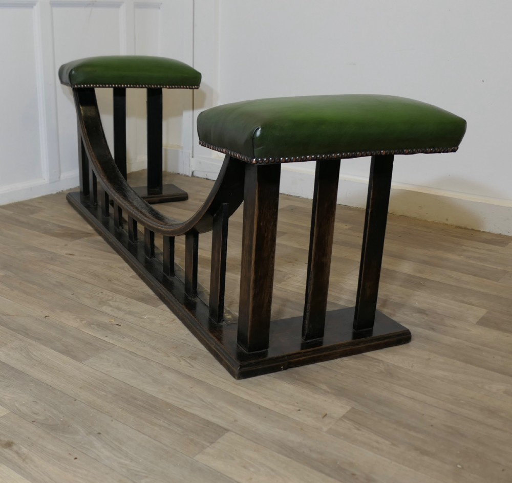 An Arts and Crafts dark oak club fender featuring two green leather upholstered seats with brass studding above vertical timber slats. View VIII