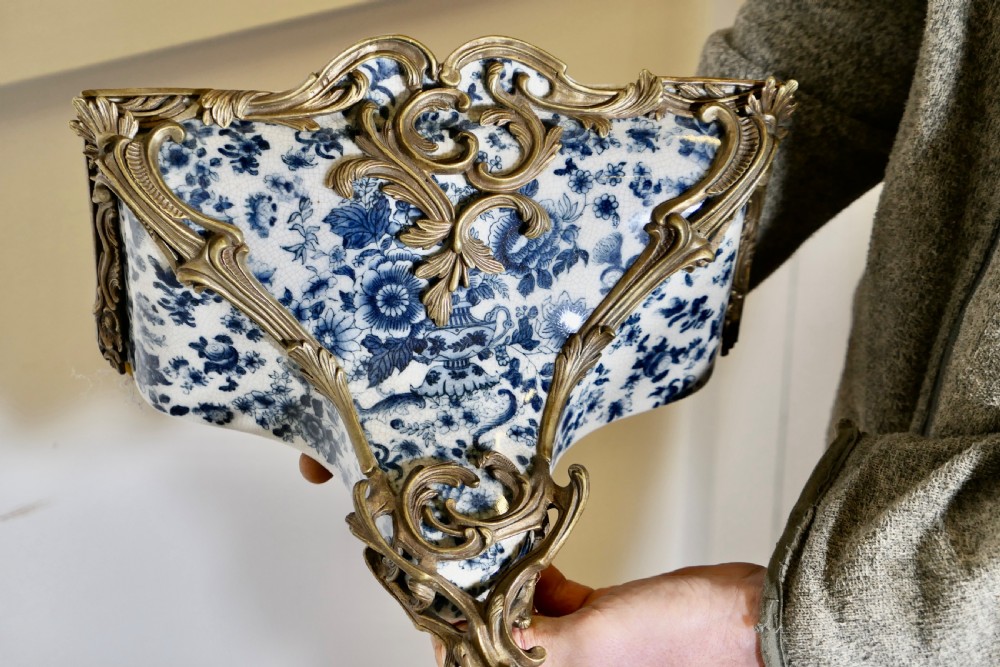 A Rococo revival wall bracket featuring blue and white floral glazed ceramic enclosed in ornamental gilt bronze foliage scrollwork. View VIII