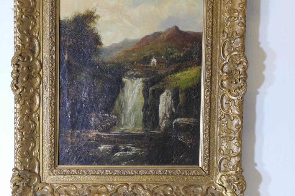 An antique Victorian oil painting depicting a cascading waterfall in a mountainous landscape, framed within an ornate gilded frame. View II