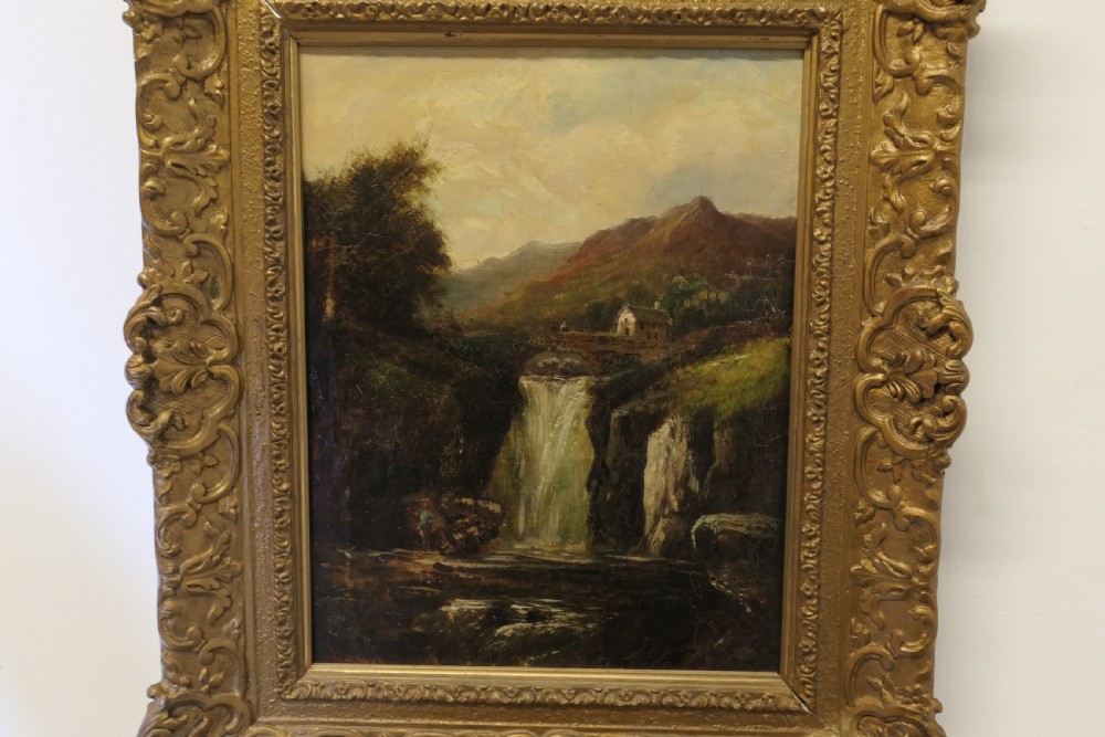 An antique Victorian oil painting depicting a cascading waterfall in a mountainous landscape, framed within an ornate gilded frame. View VII