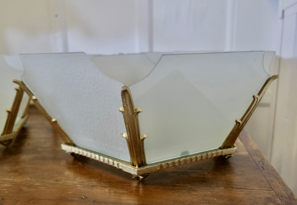 A set of six Art Deco Odeon-style pendant light shades featuring angular frosted glass panels set within brass frames. View VII