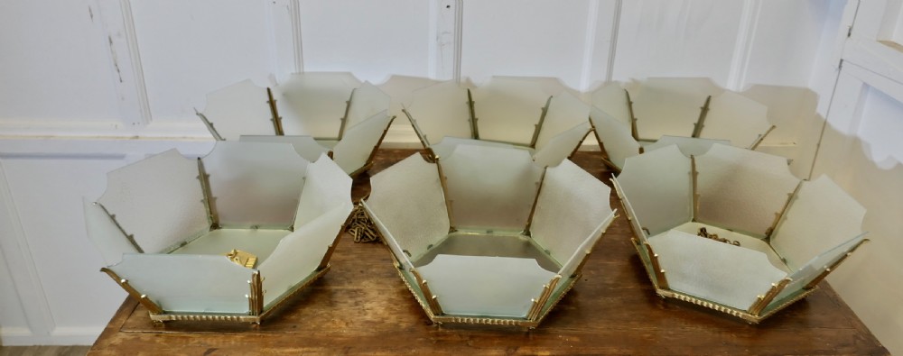 A set of six Art Deco Odeon-style pendant light shades featuring angular frosted glass panels set within brass frames.