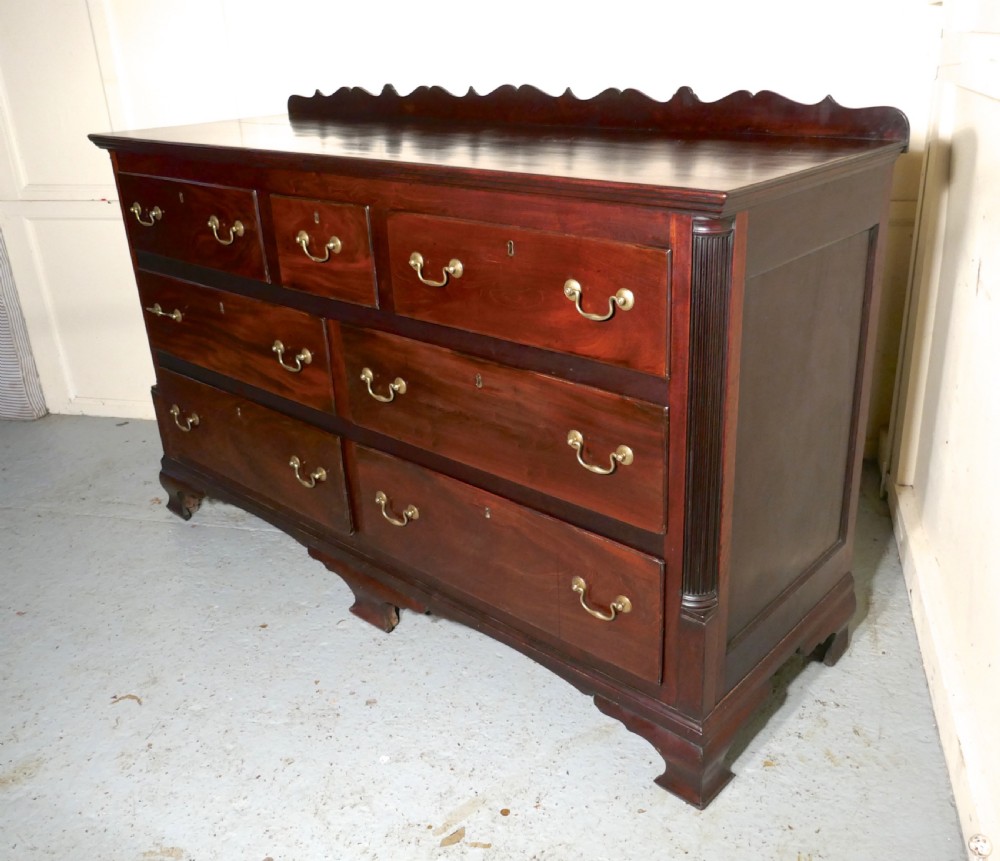 A large George III mahogany Lancashire chest of drawers with seven drawers, brass swan-neck handles, a shaped gallery upstand, and bracket feet. View V