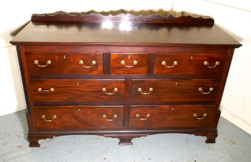 A large George III mahogany Lancashire chest of drawers with seven drawers, brass swan-neck handles, a shaped gallery upstand, and bracket feet. View VI