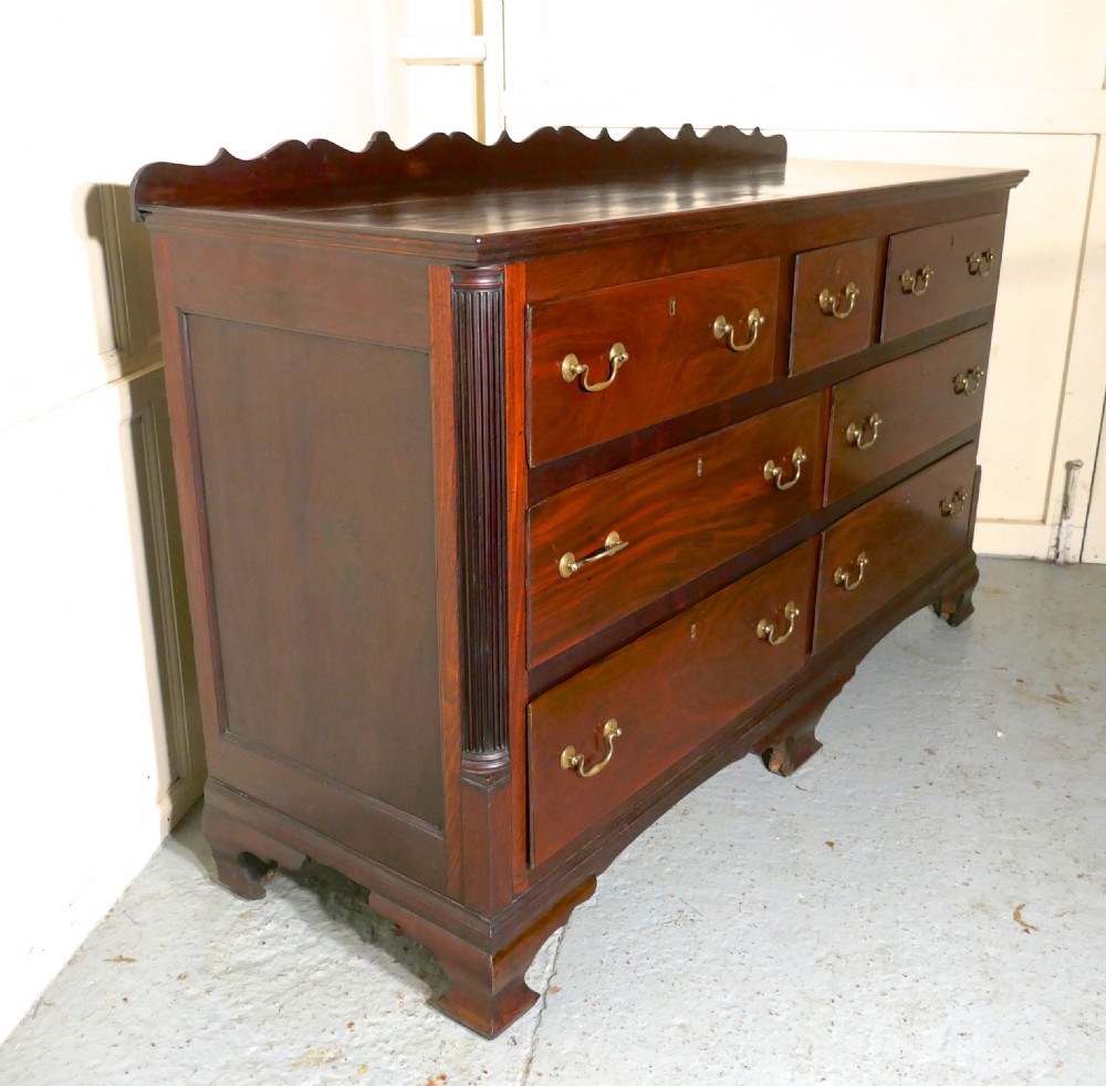 A large George III mahogany Lancashire chest of drawers with seven drawers, brass swan-neck handles, a shaped gallery upstand, and bracket feet. View VII