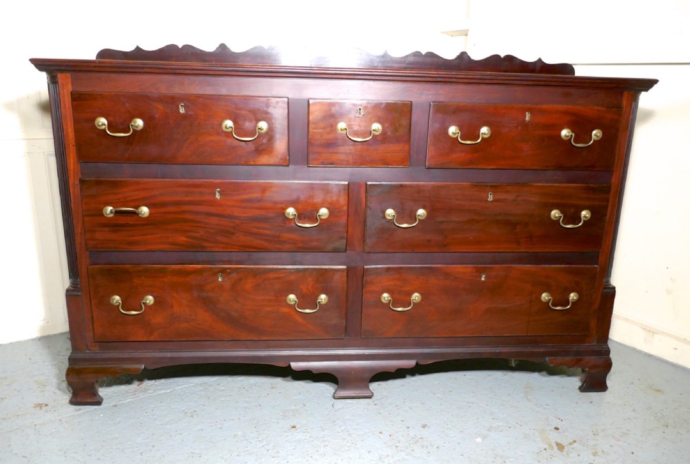 A large George III mahogany Lancashire chest of drawers with seven drawers, brass swan-neck handles, a shaped gallery upstand, and bracket feet. View VIII