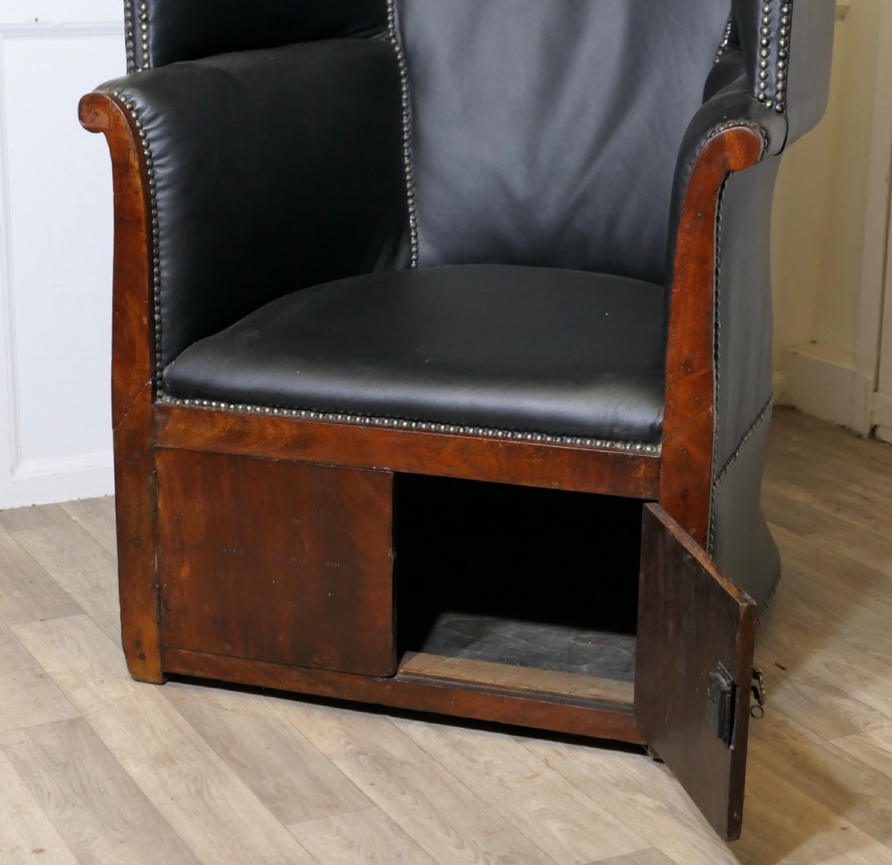 A 19th-century tall hooded hall porter chair upholstered in dark leather with stud trim and a wood base. View VIII