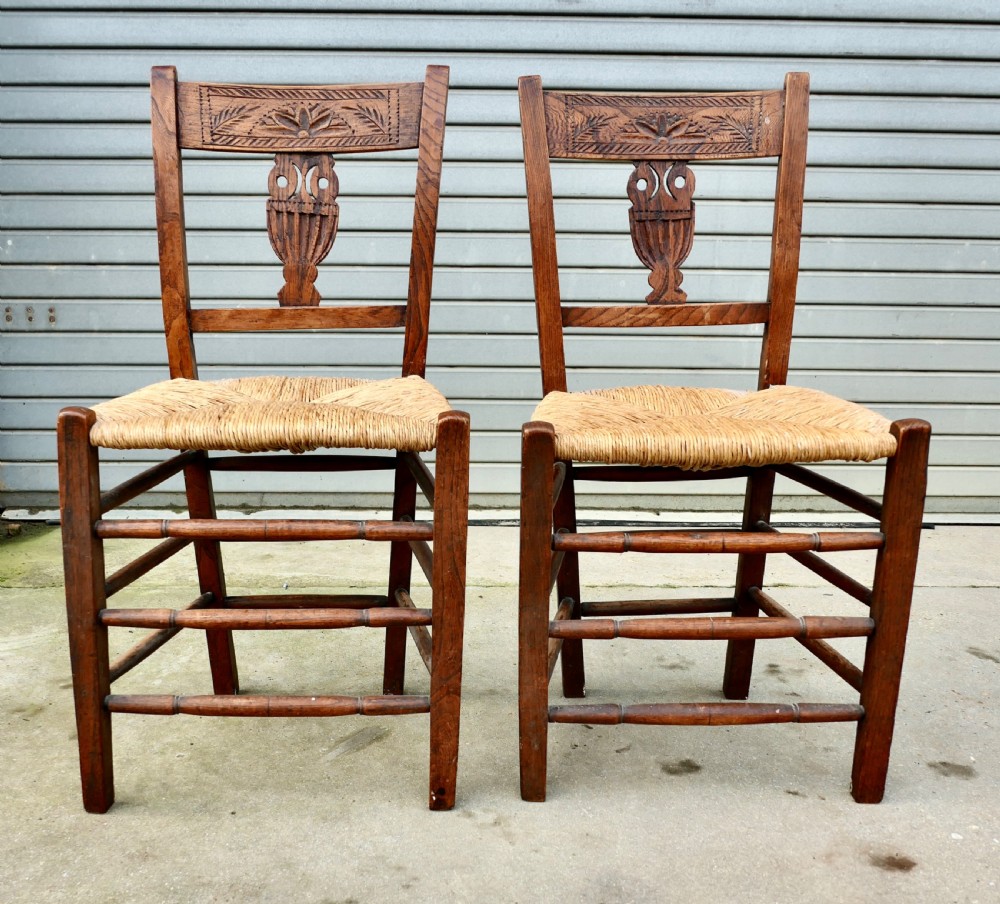 A pair of early 19th-century elm side chairs featuring carved back crests, urn-shaped splats, and woven rush seats. View IV
