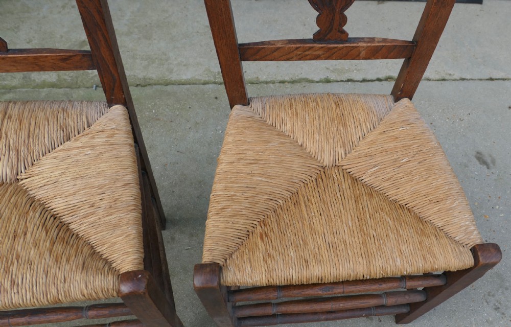 A pair of early 19th-century elm side chairs featuring carved back crests, urn-shaped splats, and woven rush seats. View VI