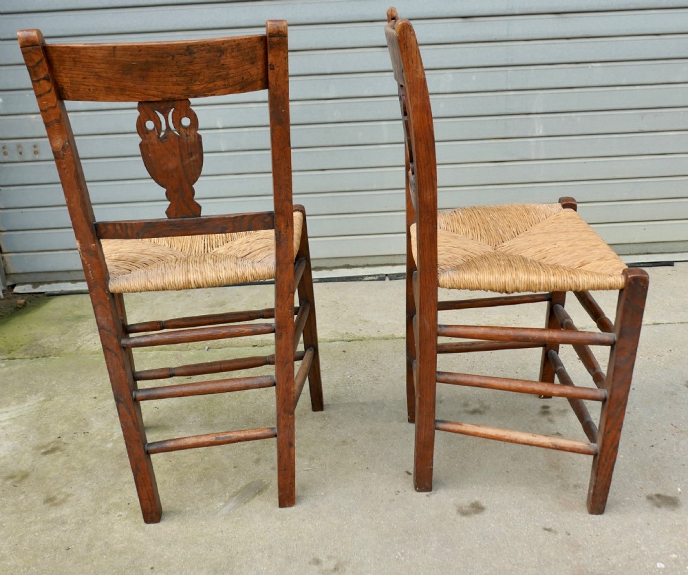 A pair of early 19th-century elm side chairs featuring carved back crests, urn-shaped splats, and woven rush seats. View VII