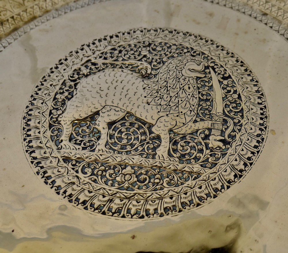 An Anglo-Indian occasional table featuring a circular hand-engraved brass tray resting on a dark carved folding wooden base. View III
