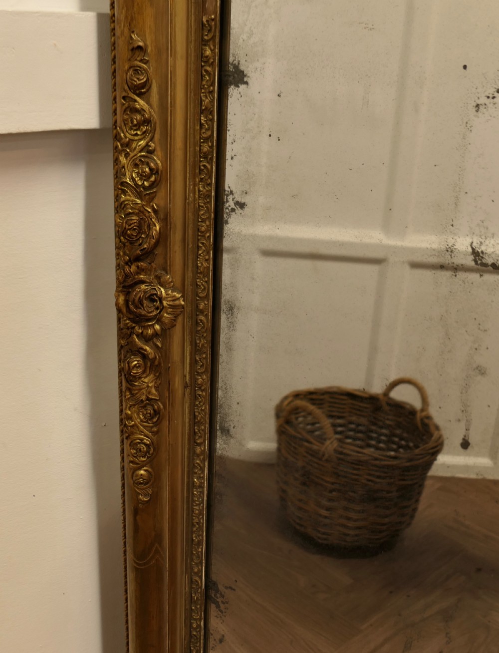 A large 19th-century French Louis Philippe style mirror with a gilded frame featuring rounded top corners and carved floral decoration. View V