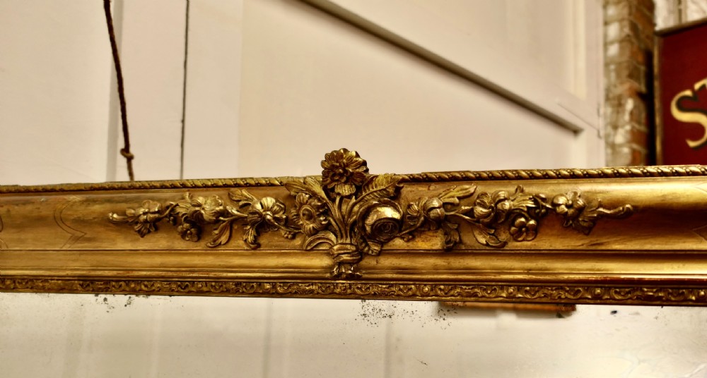 A large 19th-century French Louis Philippe style mirror with a gilded frame featuring rounded top corners and carved floral decoration. View VI