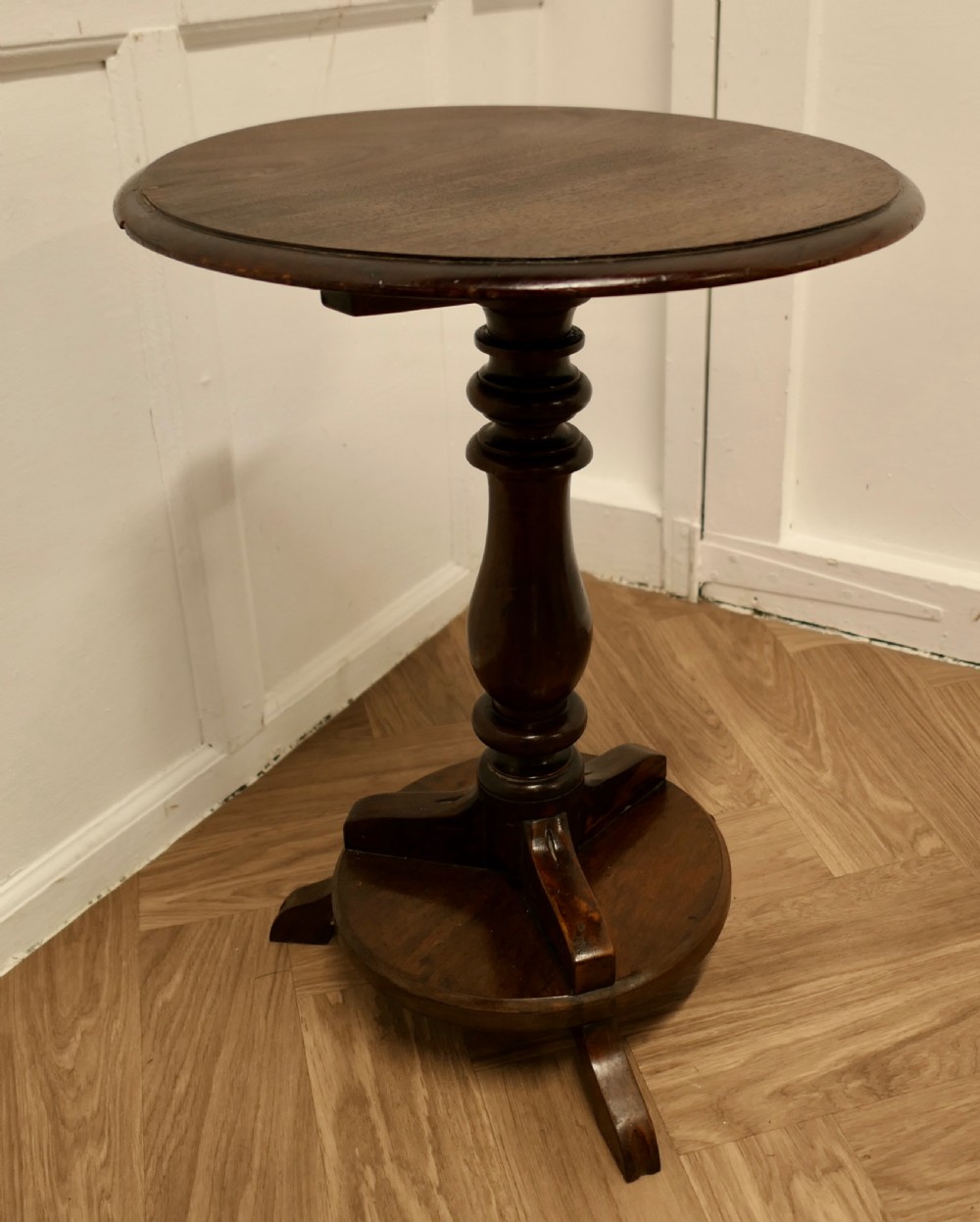 A dark brown wooden Regency style wine table featuring a round top, turned central pedestal, and tripod base. View II