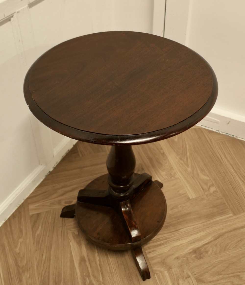 A dark brown wooden Regency style wine table featuring a round top, turned central pedestal, and tripod base. View III