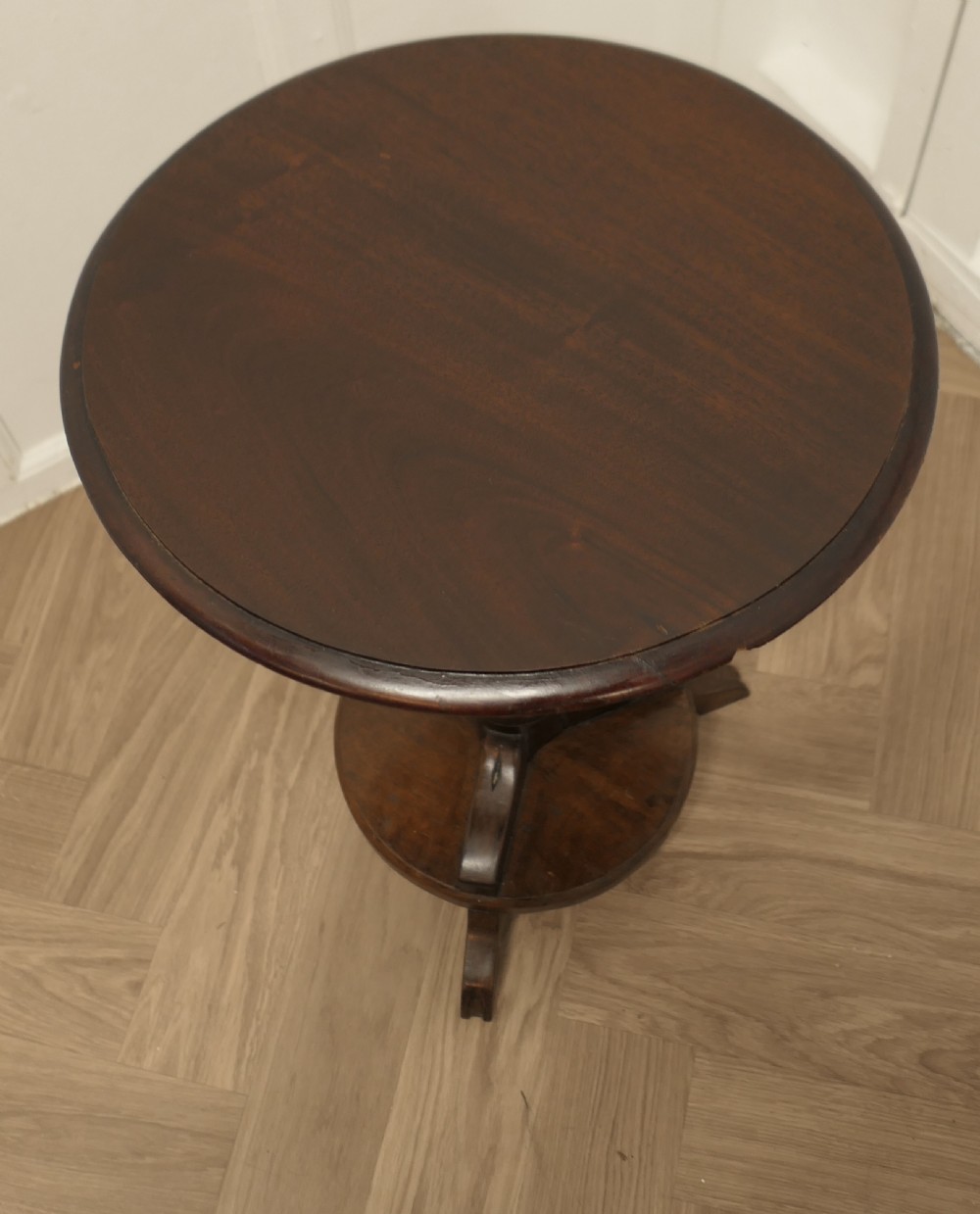 A dark brown wooden Regency style wine table featuring a round top, turned central pedestal, and tripod base. View V