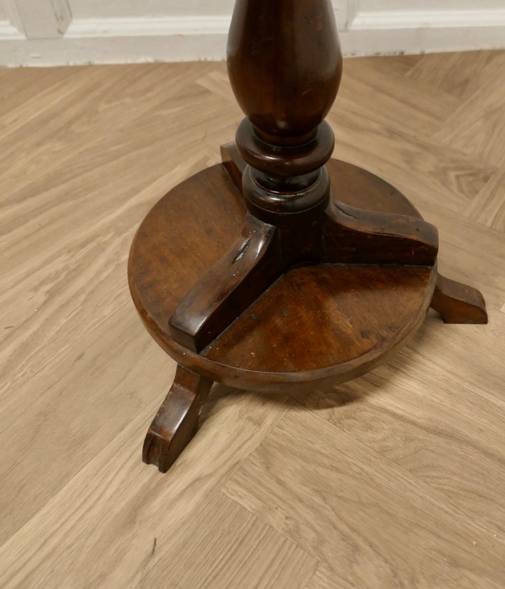 A dark brown wooden Regency style wine table featuring a round top, turned central pedestal, and tripod base. View VII