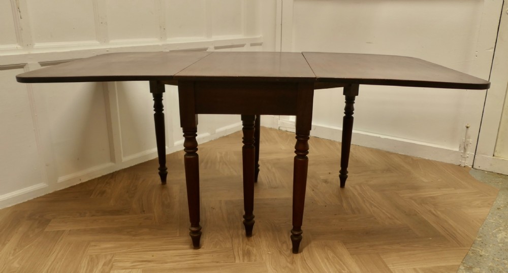 A Victorian mahogany drop-leaf table with turned legs and two hinged rectangular side flaps. View II