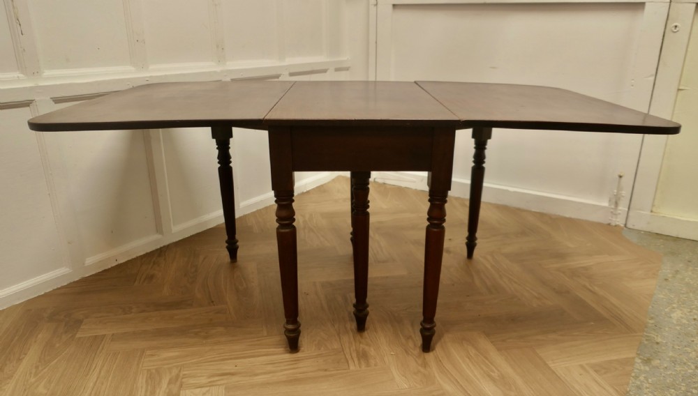 A Victorian mahogany drop-leaf table with turned legs and two hinged rectangular side flaps. View VIII
