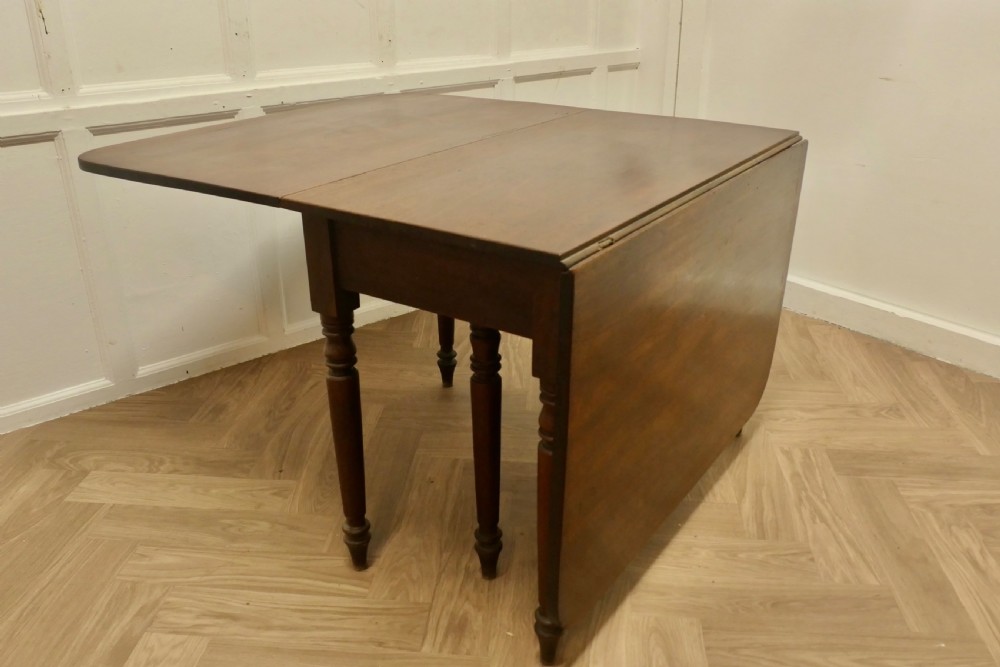 A Victorian mahogany drop-leaf table with turned legs and two hinged rectangular side flaps. View IX