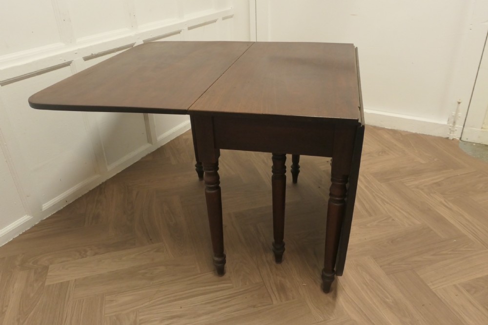 A Victorian mahogany drop-leaf table with turned legs and two hinged rectangular side flaps. View X