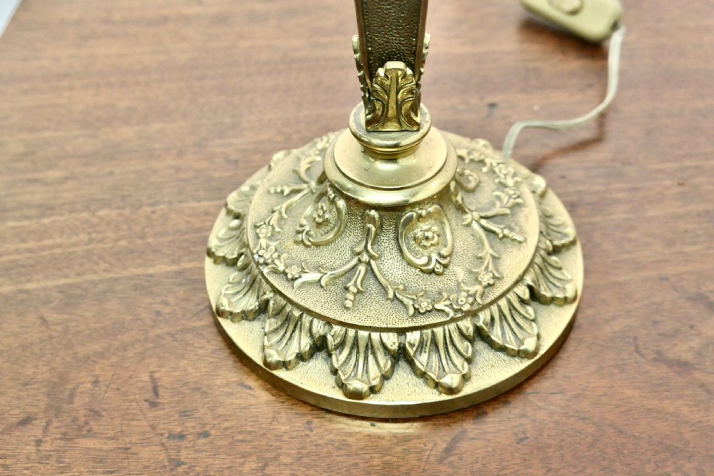 A matching pair of three-branch ornate brass electric candelabra table lamps featuring flame-shaped light bulbs and scrolled arms. View IV
