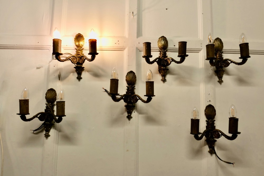 A set of six cast brass twin-branch wall lights featuring scallop shell cresting and twin bulb holders. View II