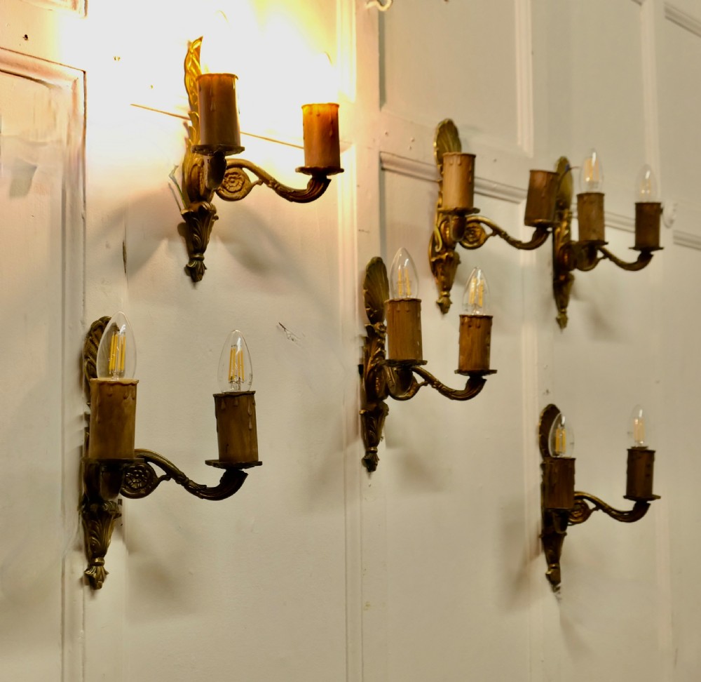 A set of six cast brass twin-branch wall lights featuring scallop shell cresting and twin bulb holders. View V