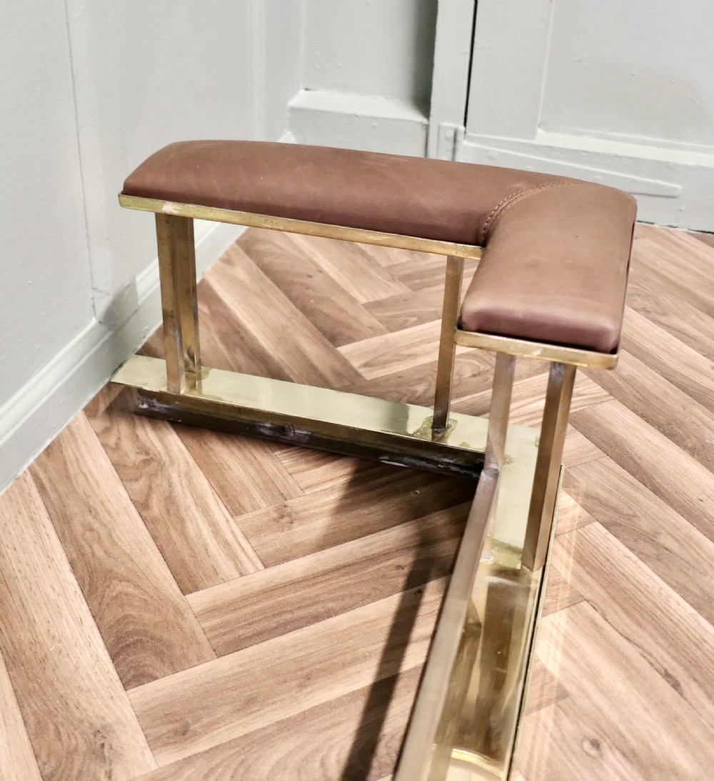 An Art Deco polished brass club fender featuring two corner seats upholstered in tan leather. View IV