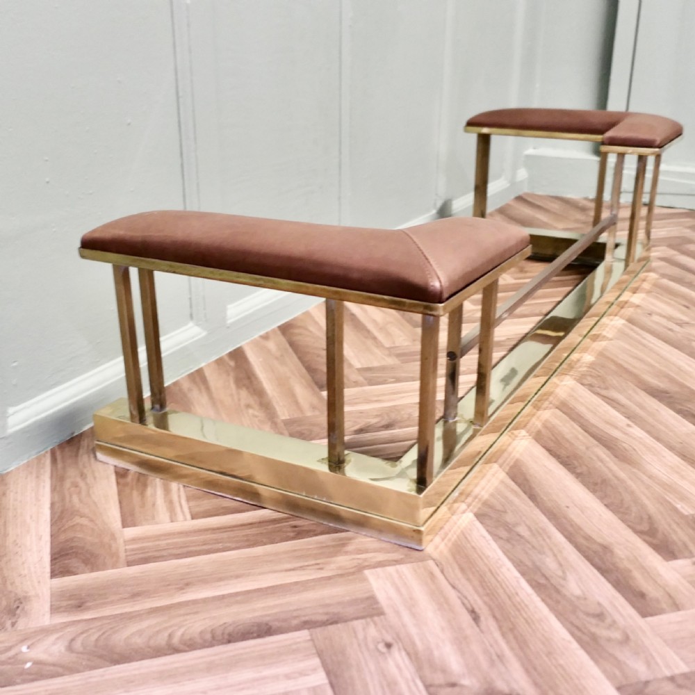 An Art Deco polished brass club fender featuring two corner seats upholstered in tan leather. View VI