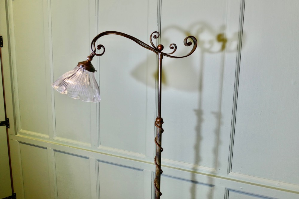 A dark wrought iron telescopic floor lamp featuring scrollwork arms, a spiral-wrapped stem, a quadruped base, and a clear fluted glass shade. View II