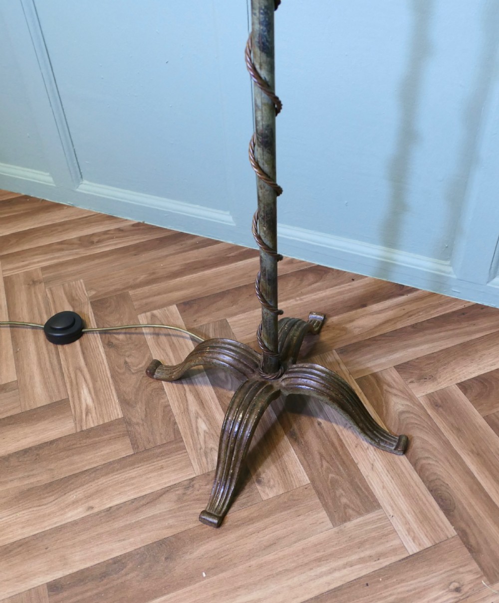 A dark wrought iron telescopic floor lamp featuring scrollwork arms, a spiral-wrapped stem, a quadruped base, and a clear fluted glass shade. View IX