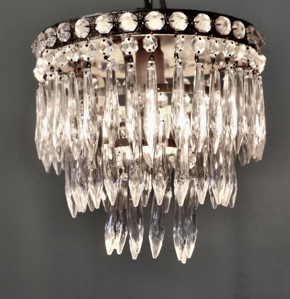 A petite tiered waterfall pendant chandelier featuring faceted cut glass droplets suspended from an ornate circular brass rim. View III