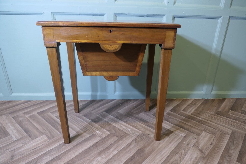 An Edwardian satin walnut sewing work table with tapered square legs, a fitted central drawer, and decorative fan marquetry inlay.
