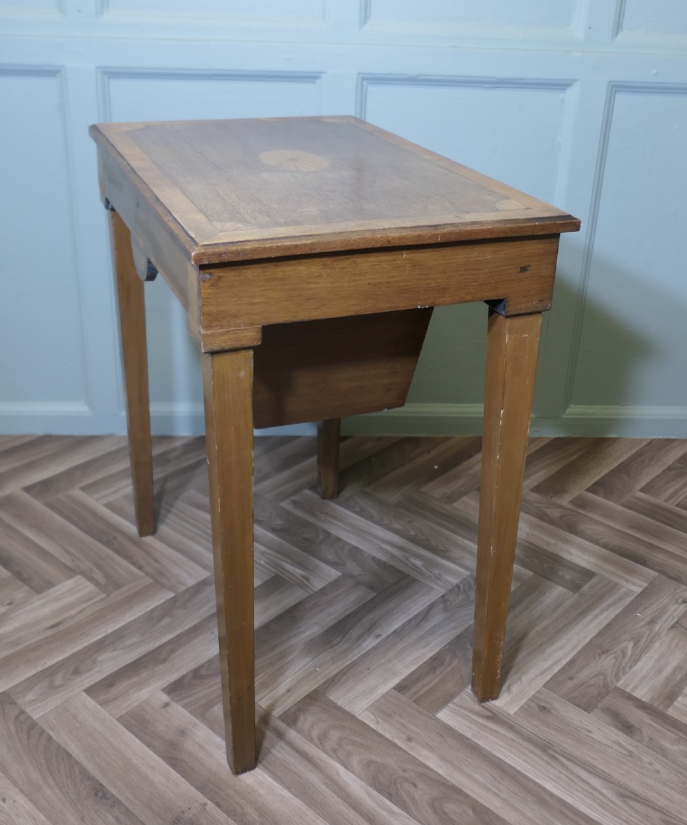 An Edwardian satin walnut sewing work table with tapered square legs, a fitted central drawer, and decorative fan marquetry inlay. View VII