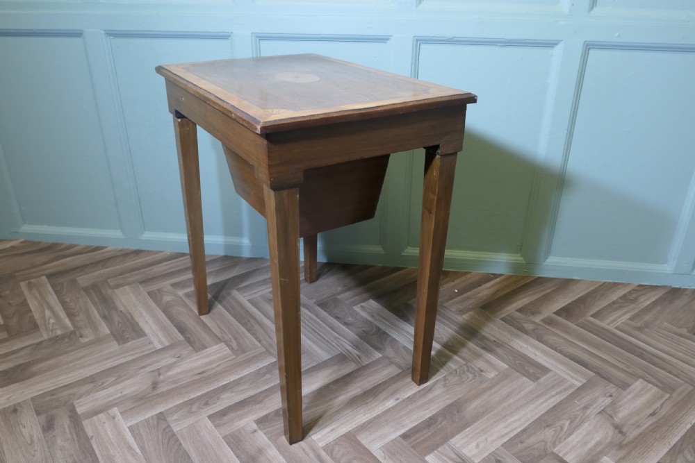 An Edwardian satin walnut sewing work table with tapered square legs, a fitted central drawer, and decorative fan marquetry inlay. View IX