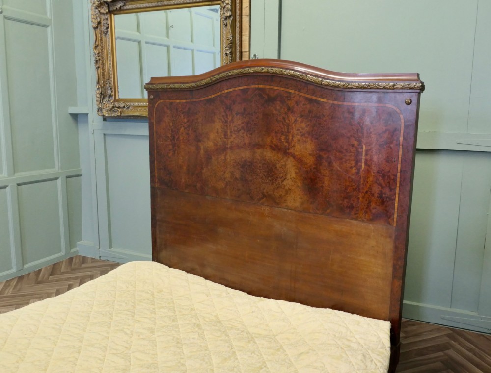 An Art Deco French style double bed featuring a shaped burr walnut headboard and footboard with gilt metal mounts. View III