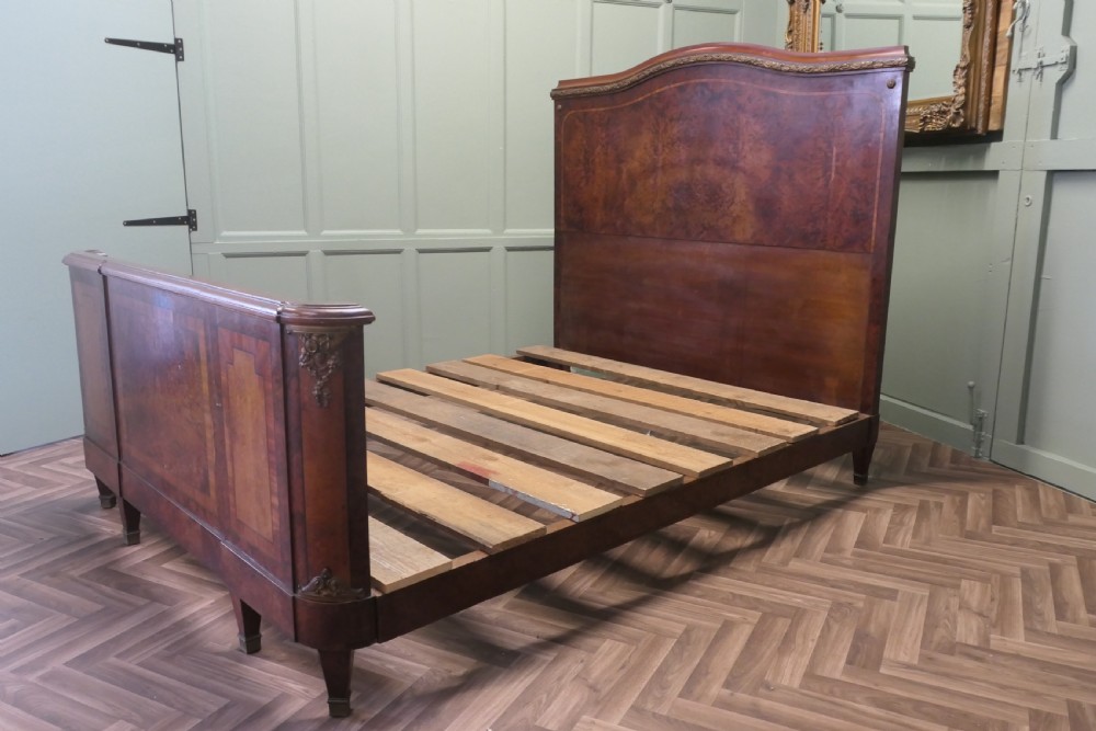 An Art Deco French style double bed featuring a shaped burr walnut headboard and footboard with gilt metal mounts. View VIII