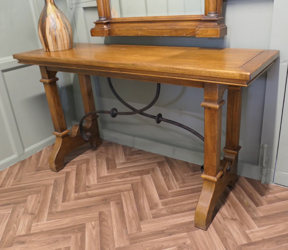 A golden oak console table featuring curved wrought iron stretchers paired with a matching framed wall mirror. View V