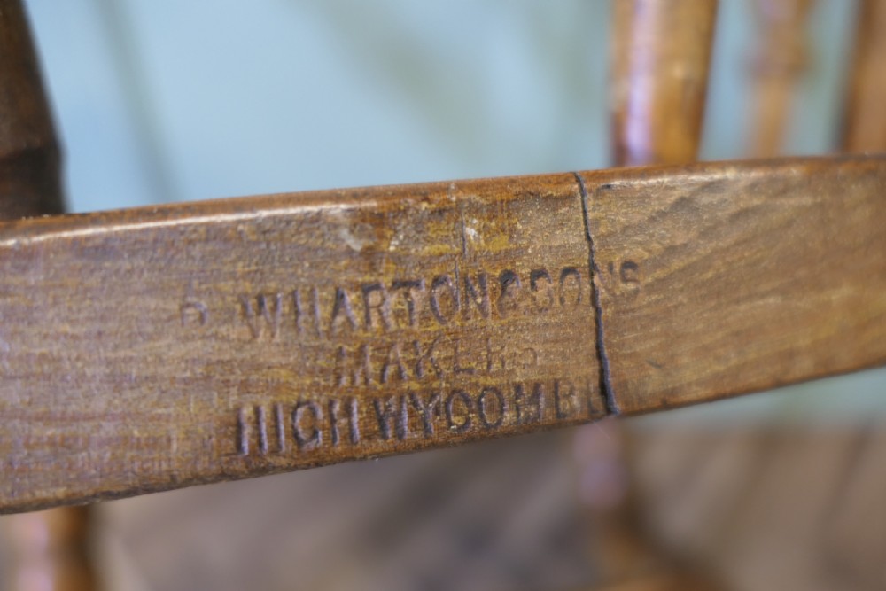 A 19th-century wooden smokers bow armchair featuring a curved crest rail, turned baluster spindles, a carved saddle seat, and turned legs. View VI